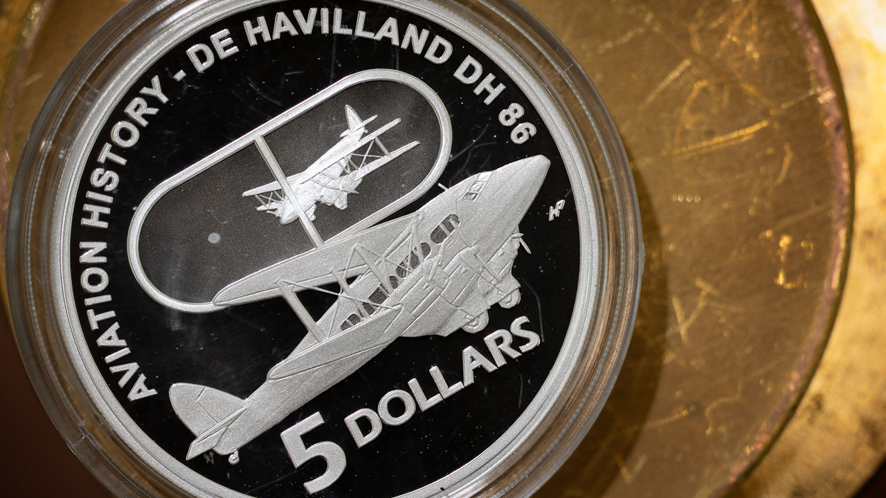 Silver five dollar aviation history coin with plane design