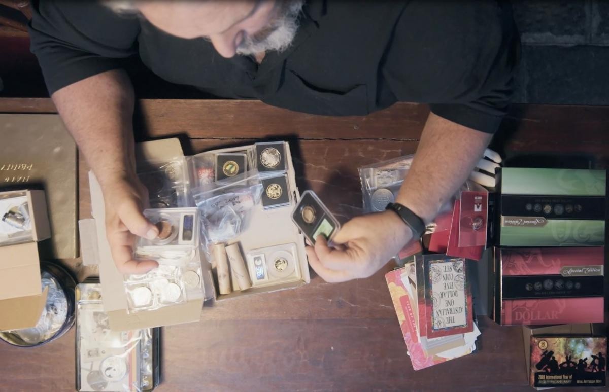 Why people collect - Collector in desk looking at coins