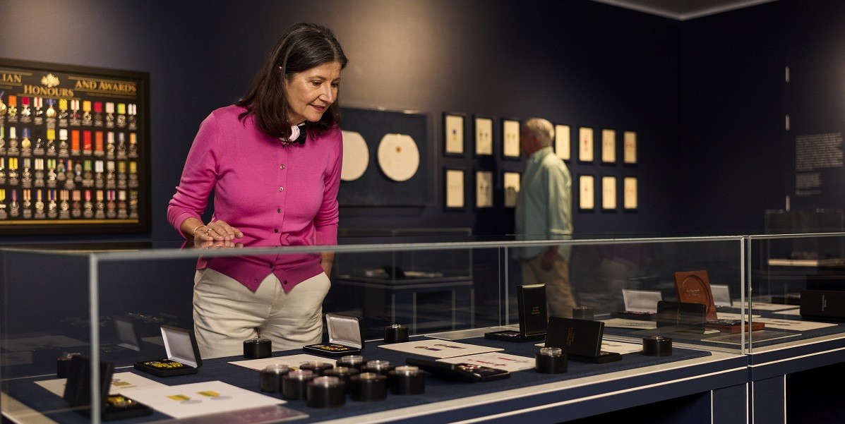 Honours Exhibition with woman looking at the display case