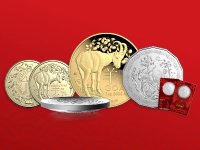 Four Lunar Year of the Goat coins against a red background.