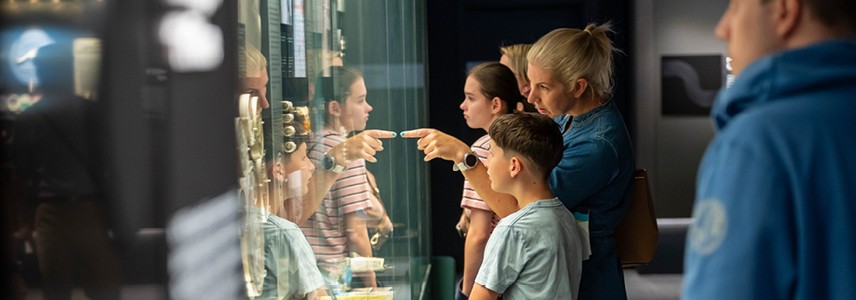 A family looks into a glass coin display at the Royal Australian Mint.
